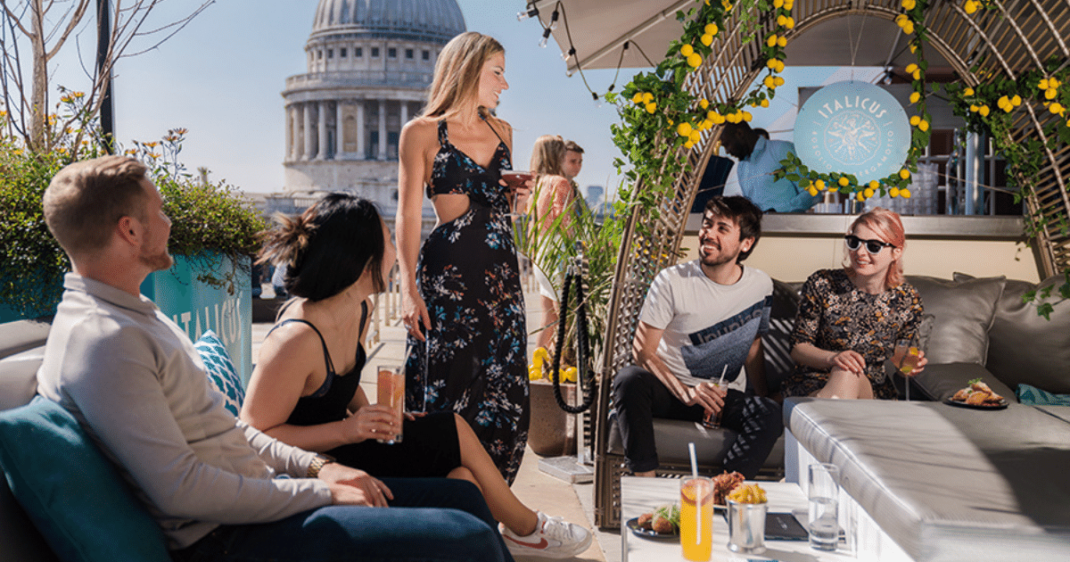 Friends enjoying drinks at a rooftop bar in the City of London