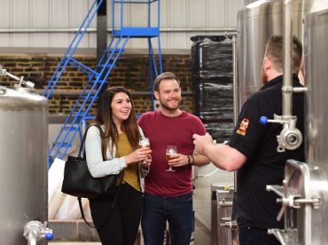 Couple tasting beer on a brewery tour