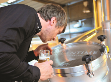A man looks into a maturation tank while on a tour of Meantime Brewery in Greenwich.