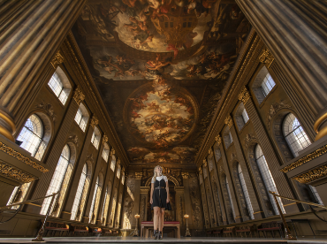 A lady looks up at the ceiling of the Painted Hall - dwarfed by its scale.