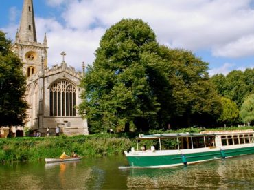 Boat on river in front of church