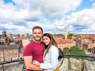 Couple taking photo with view of York behind
